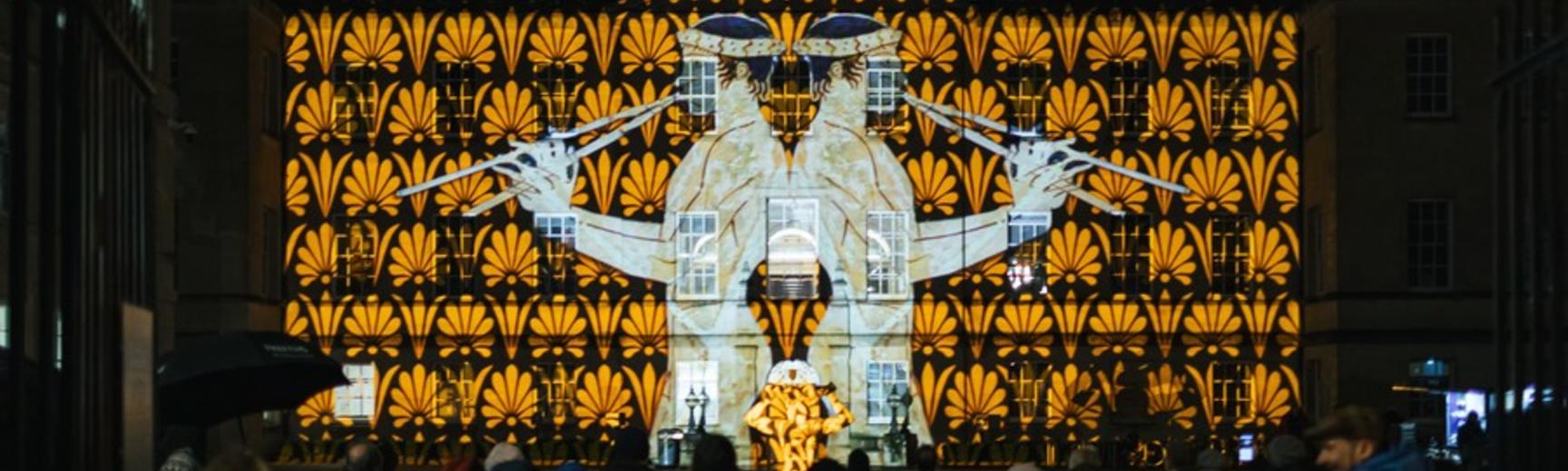 Lights projected onto the front of the Radcliffe Humanities Building