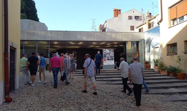 Image depicts the opening day of the ISTROX exhibition at Lapidarium with walking people towards the entrance.