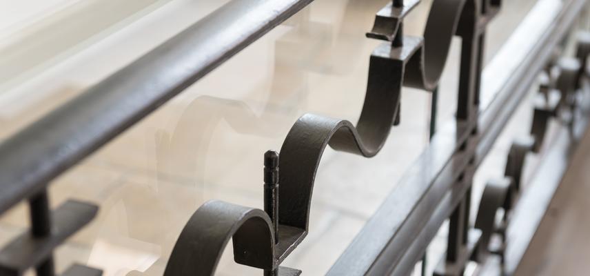 Photo of a metal bannister with a wavy pattern.