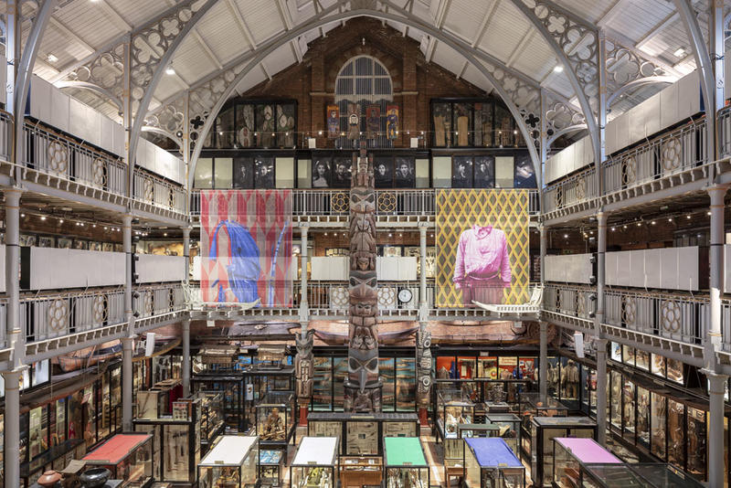 Interior view of the Pitt River Museu with bright exhibition banners up over the glass cabinets