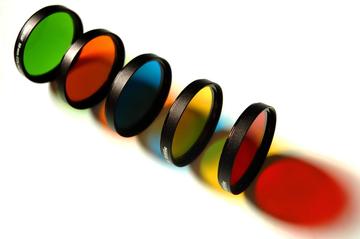 Five lenses one behind the other, each a different colour: green, orange, blue, yellow and red.