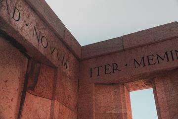 A wall structure with a window and the latin words Novum Iter engraved on the Lintel.