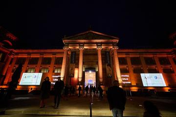Warmly lit exterior of the Ashmolean Museum in the dark
