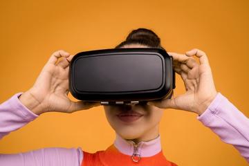 woman wearing VR headseat against orange background