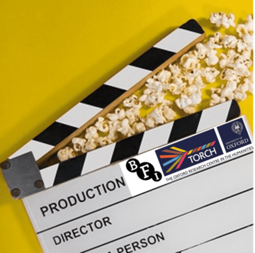 Image displays a clapboard on a yellow background with scattered popcorn between the open clap. Clapboard by GR Stocks on Unsplash