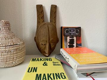 Igbo mask with a copy of 'Making and Un Making by Duro Olowu