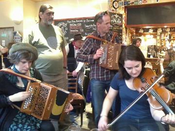Three musicians at Oxford Folk Festival in a pub in 2013. Two musicians playing the accordeon and KE Fellow Alice Little (at bottom right) playing the violine. 