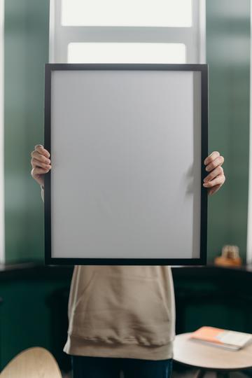 A person holds up a blank poster.