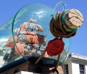 Installation of a gigantic plastic bottle containing a ship 'miniature'.
