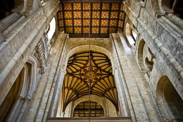 Photo of the interior of Winchester Cathedral looking up at the vaulting and wooden ceiling of an aisle