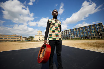 John Falsetto holding the mbira before the Radcliffe Observatory