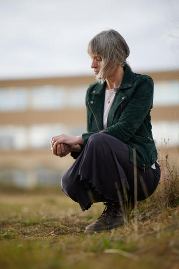 Alice Oswald crouching on the Schwarzman Centre site