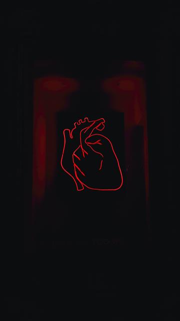 Image of a red neon heart outlined against a dark background. The background is mainly black with two dark red patches.