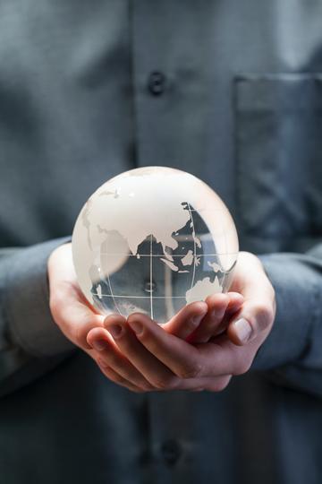 Photo of a person holding a small globe in their hands
