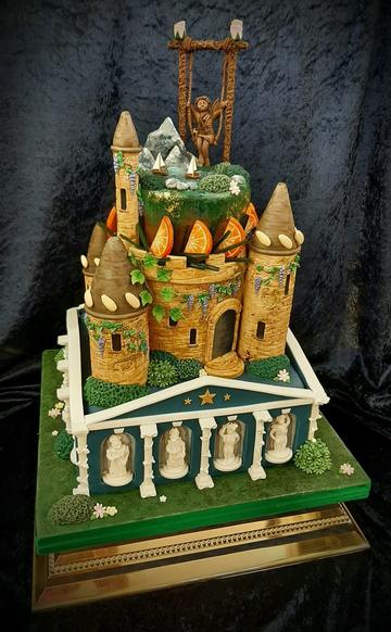Large cake in the shape of a castle atop a Greek pantheon-style building