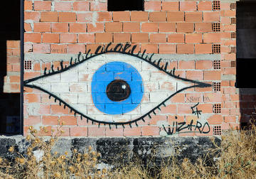 Graffiti image of a blue eye on a wall in Athens