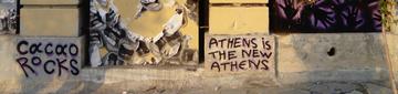 The bottom of a mural in Metaxourgeio by Cacao Rocks stating, “Athens is the new Athens”, photo taken by the authors in July 2018