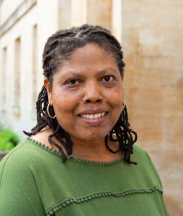 Professor Audrey Mbogho, wearing a green shirt, smiling at the camera