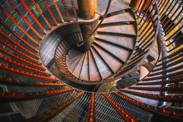 A photograph of an iron spyral staircase looking top-down