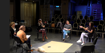 actors sit on chairs in a circle