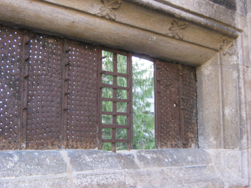 medieval window with metal inserts and stone surround