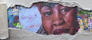 Graffiti art of Toni Morrison showing through ripped paper