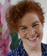 Headshot of Karen Leeder, a smiling woman with a blue patterned shirt.