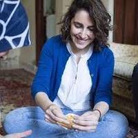 Itab azzam woman sitting on the floor crossed legged smiling