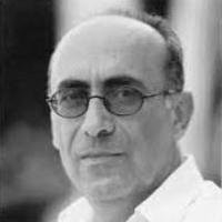 Mamdouh azzam black and white photo of man with glasses sitting side on to camera wearing white shirt