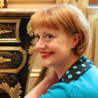 Mia Jackson, Curator of Decorative Arts at Waddesdon Manor, smiling, wearing a turquoise cardigan.