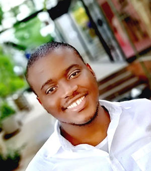 Dr Gcobani Qambela in white shirt smiling at camera