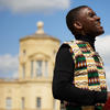 John Falsetto holding the mbira and singing on a sunny day in front of the Radcliffe Observatory