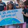 children hold signs for climate crisis awareness