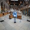 woman in blue stands in front of dinosaur bones in Oxford Natural history Museum