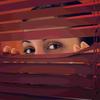 Image of woman looking through blinds