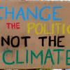 cardboard sign reading change the politics not the climate