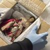 Image depicts the unpacking of a 18th century doll's house doll wearing a lace embroidered red gown (Nostell Priory, West Yorkshire).